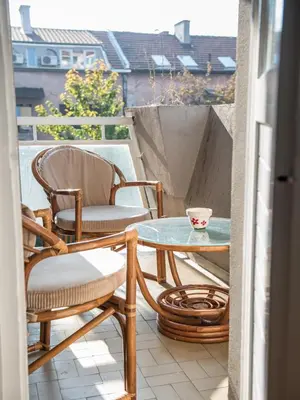 a patio with two chairs and a glass table on a balcony at Apartment Marshall Resavska in Belgrade