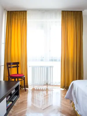 a bedroom with a bed and a chair and a large window at Apartment Marshall Resavska in Belgrade