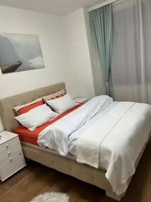 a bedroom with a bed with white sheets and a window at The Gates Apartments Belgrade Waterfront in Belgrade