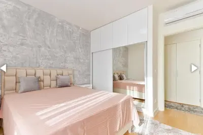 a bedroom with a large bed and a mirror at The Gates Apartments Belgrade Waterfront in Belgrade