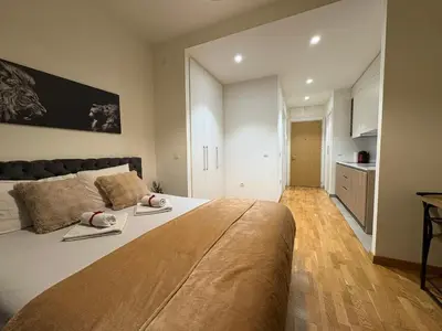 a bedroom with a large bed and a kitchen at Solis BW Apartments in Belgrade
