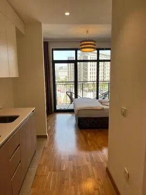 a room with a bed and a kitchen with a large window at Solis BW Apartments in Belgrade