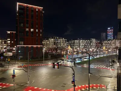 an empty city street at night with buildings and street lights at Solis BW Apartments in Belgrade