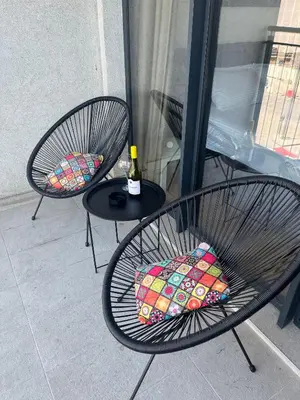 two chairs and a table with a bottle of wine at Solis BW Apartments in Belgrade