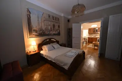 a bedroom with a bed and a painting on the wall at La Mascarade in Belgrade