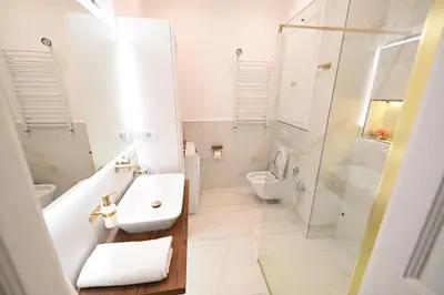 a white bathroom with a sink and a shower at La Mascarade in Belgrade