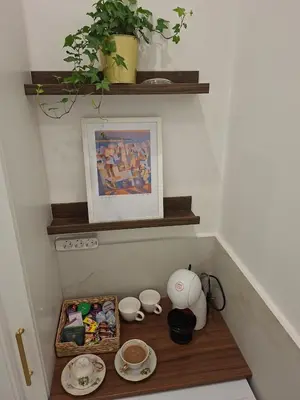 a room with a shelf with a table with bowls and cups at La Mascarade in Belgrade