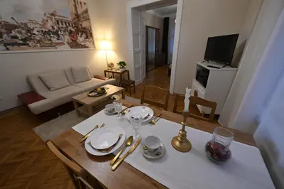 a living room with a table with plates and silverware at La Mascarade in Belgrade