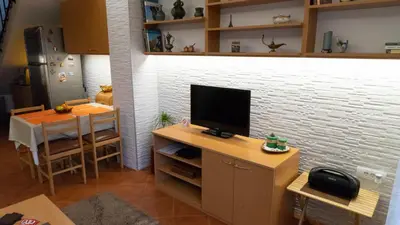a living room with a television and a table with a dining room at Apartment Akacija Gardens in Belgrade