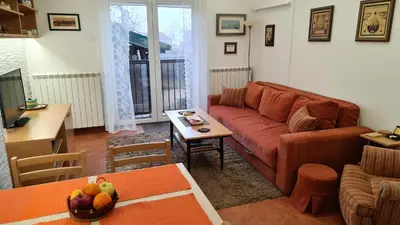 a living room with a couch and a table at Apartment Akacija Gardens in Belgrade