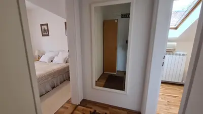 a bedroom with a bed and a mirror at Apartment Akacija Gardens in Belgrade