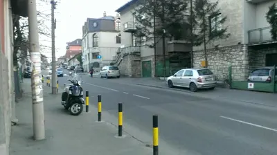 a scooter parked on the side of a city street at Apartment Akacija Gardens in Belgrade