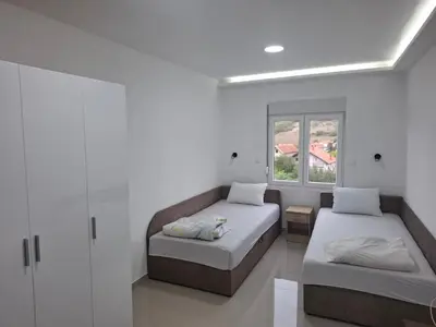 a bedroom with two beds and a window at Apartman SARA in Smederevo