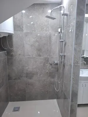 a shower with a glass door in a bathroom at Apartman SARA in Smederevo