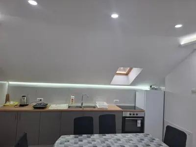 a kitchen with a sink and a counter with chairs at Apartman SARA in Smederevo