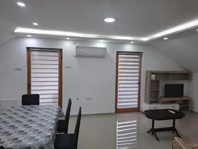 a white room with a table and chairs and windows at Apartman SARA in Smederevo