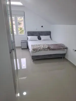 a bedroom with a bed in a white room at Apartman SARA in Smederevo