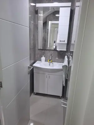 a white bathroom with a sink and a mirror at Apartman SARA in Smederevo