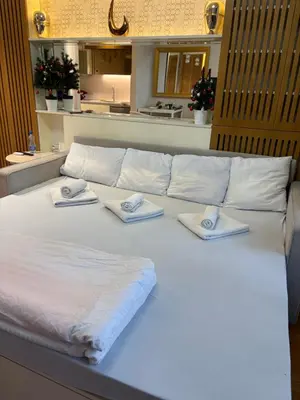 a large white bed with towels on top of it at Lunalux BW Apartments in Belgrade