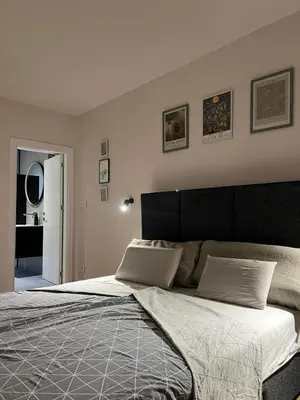 a bedroom with a large bed with a black headboard at Sovica- Taš in Belgrade