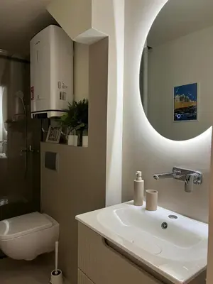 a bathroom with a sink and a toilet and a mirror at Sovica- Taš in Belgrade
