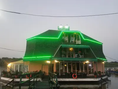 a building with a green roof on the water at Hostel Otard in Belgrade