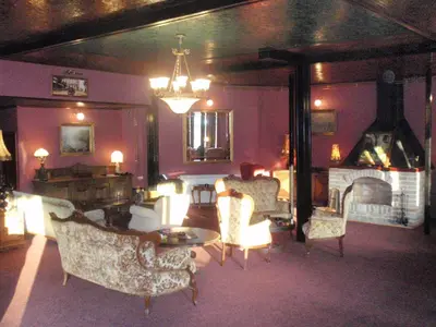 a living room with chairs and a table and a fireplace at Hostel Otard in Belgrade