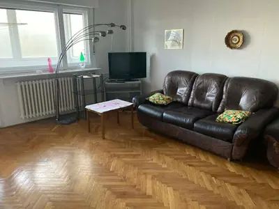a living room with a leather couch and a table at VukTas in Belgrade