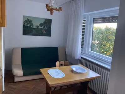 a living room with a table and a couch and a window at VukTas in Belgrade