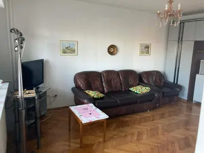 a living room with a brown leather couch and a table at VukTas in Belgrade