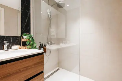 a white bathroom with a shower and a sink at WF 104m2 Prestige with Terrace, Gym and Pool in Belgrade