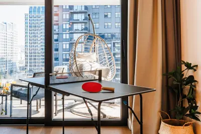 a table and a chair in a room with a window at WF 104m2 Prestige with Terrace, Gym and Pool in Belgrade