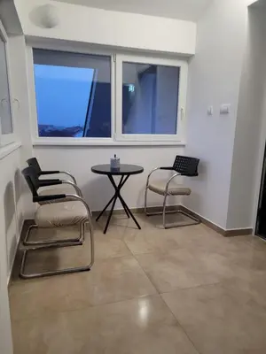 a room with two chairs and a table and two windows at Beosan in Železnička Stanica Zemunsko Polje