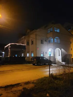 a car parked in front of a building at night at Beosan in Železnička Stanica Zemunsko Polje