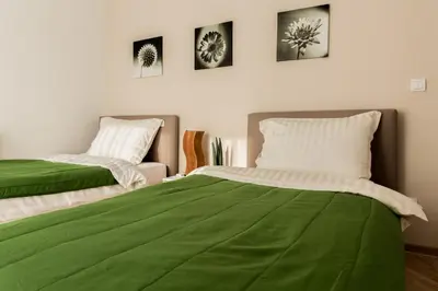 two beds in a room with green sheets at Apartment Admiral in Belgrade