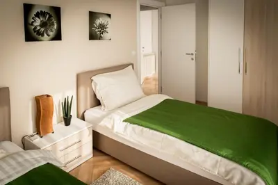 a bedroom with a large bed with a green blanket at Apartment Admiral in Belgrade