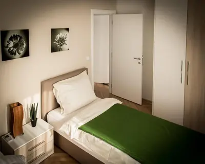 a bedroom with a bed with a green blanket at Apartment Admiral in Belgrade