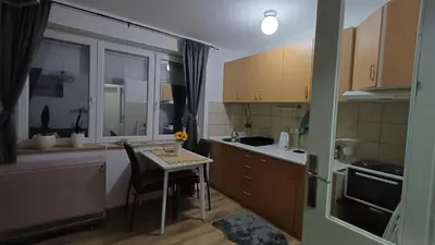 a small kitchen with a table and a small table with a chair at Apartman Borkica in Mladenovac
