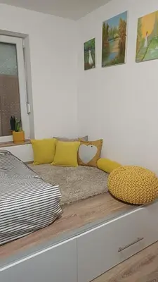 a bed with yellow pillows on top of a counter at Apartman Borkica in Mladenovac
