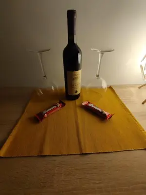 a bottle of wine and two glasses on a table at Apartman Borkica in Mladenovac