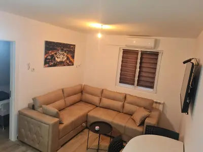 a living room with a brown couch and a window at Marash 3 in Belgrade