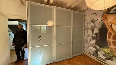 a man walking through a room with a large glass wall at vila filip in Belgrade