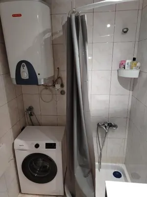 a bathroom with a washing machine and a shower at LoLo apartment Belgrade in Beograd