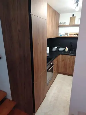 a kitchen with wooden cabinets and a black counter top at LoLo apartment Belgrade in Beograd
