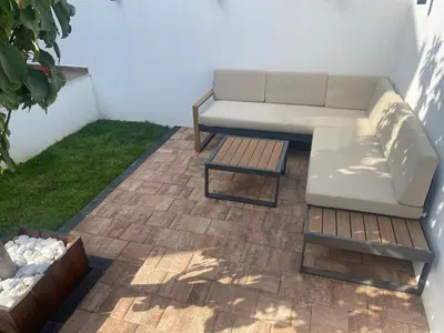 a couch and a coffee table on a patio at LoLo apartment Belgrade in Beograd