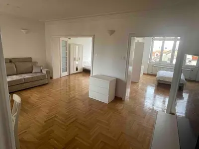 a living room with a couch and wooden floors at New Luxury Strict Center Apartment in Belgrade