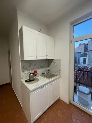 a kitchen with white cabinets and a sink and a window at New Luxury Strict Center Apartment in Belgrade