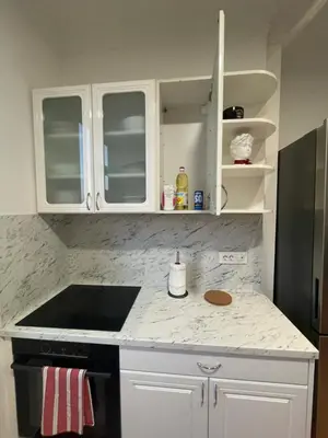 a kitchen with white cabinets and a counter top at New Luxury Strict Center Apartment in Belgrade
