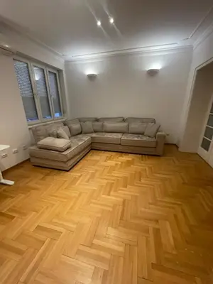 a living room with a couch and a wooden floor at New Luxury Strict Center Apartment in Belgrade
