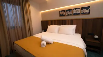 a hotel room with a bed with a towel on it at Hotel Central in Inđija